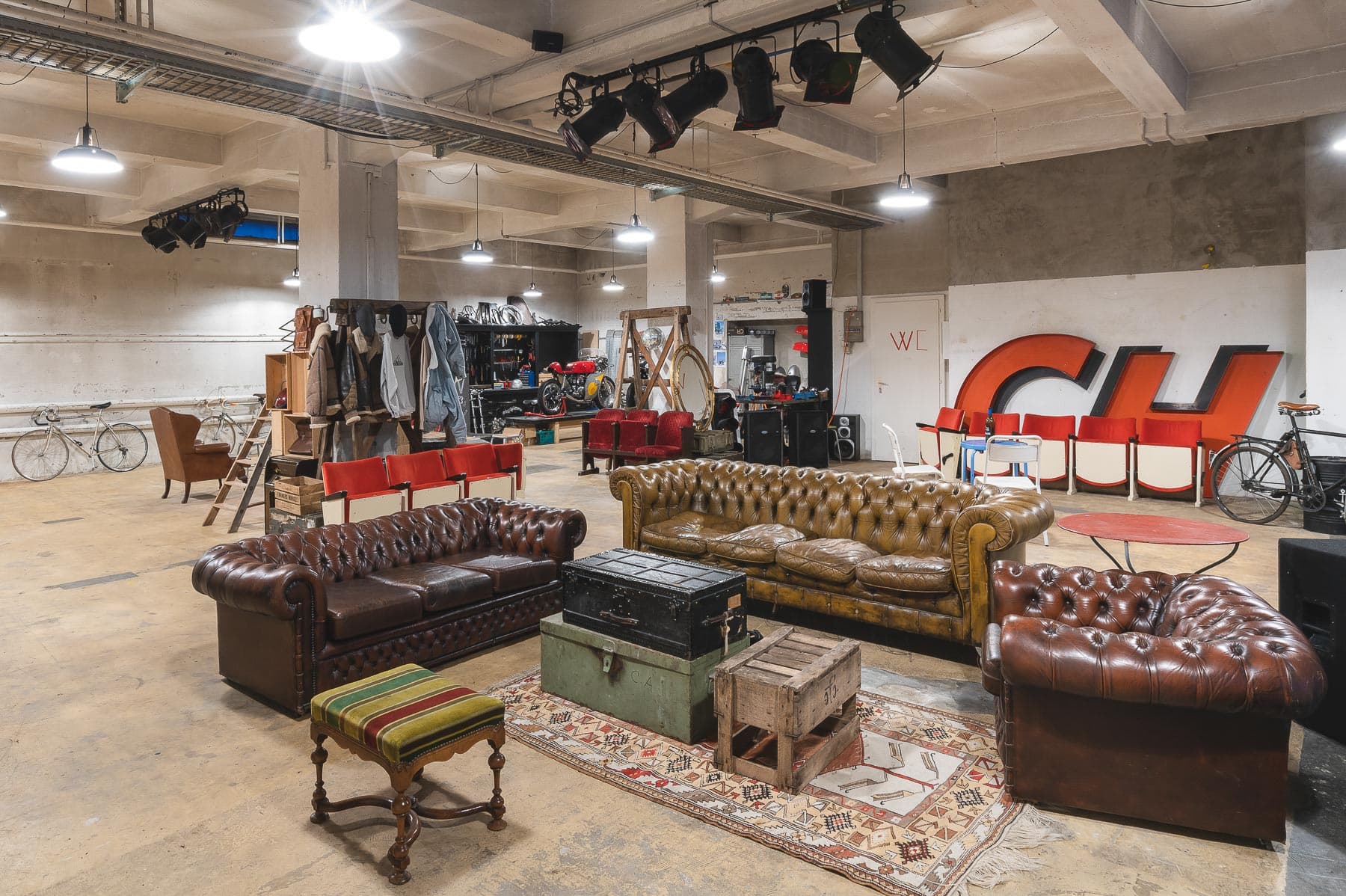 Intérieur d'entrepôt de 240m² mettant en valeur la lumière naturelle à travers de grandes fenêtres, plafond industriel exposé et espace ouvert polyvalent parfait pour événements privés, expositions et célébrations à Lausanne