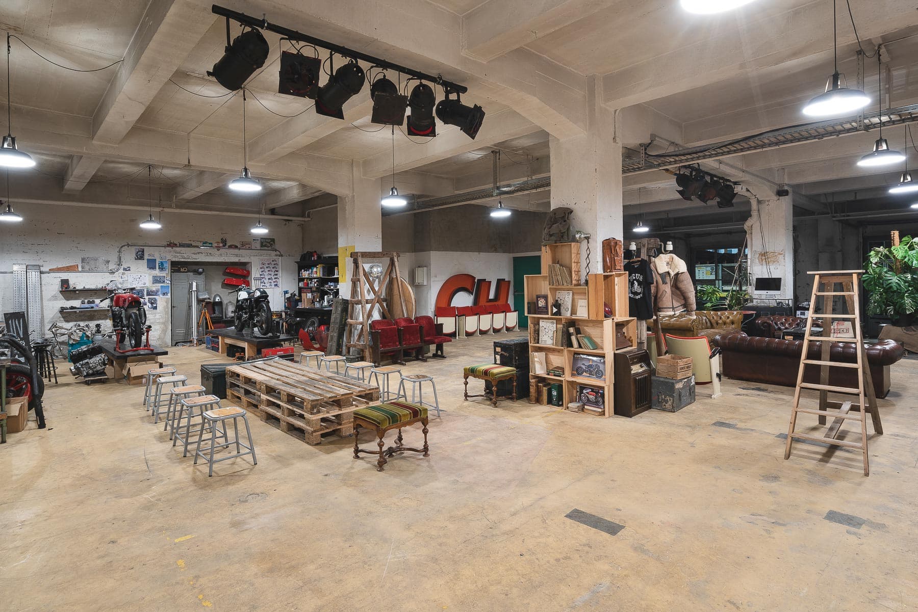 Intérieur d'entrepôt de 240m² mettant en valeur la lumière naturelle à travers de grandes fenêtres, plafond industriel exposé et espace ouvert polyvalent parfait pour événements privés, expositions et célébrations à Lausanne